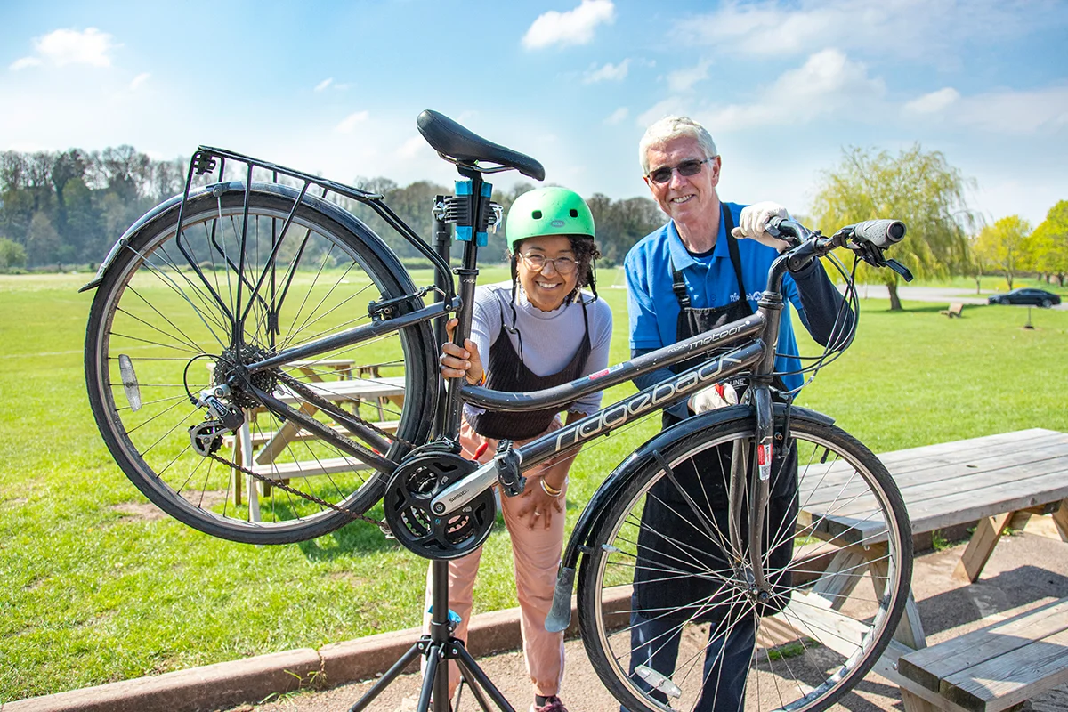 botm-featured Dr Bike posing with customer holding repaired bike